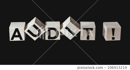 Word AUDIT text on wooden blocks and black background. 106913219