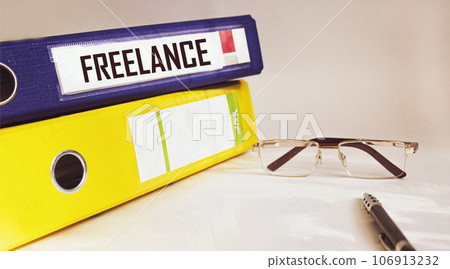 Two folders are on a white background, one with the word FREELANCE written on it. Two folders are on a white background, one with the word FREELANCE written on it. 106913232