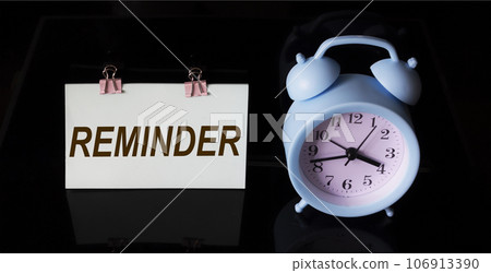 Reminder, text on sticker. There is an alarm clock on a black background Reminder, text on sticker. There is an alarm clock on a black background 106913390
