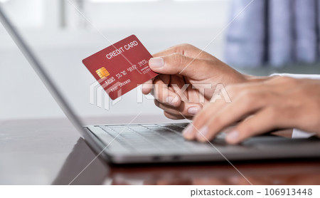 Young Asian consumer businessmen hand holding mock-up credit card, Ready to spending pay online shopping according to discount products via laptop from home office Young Asian consumer businessmen hand holding mock-up credit card, Ready to spending pay online shopping according to discount products via laptop from home office 106913448
