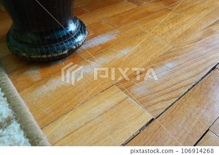 Scratched old parquet flooring needs maintenance. The parquet is damaged by scratches from prolonged use. The leg of an antique wooden bed scratched the floor. Scratched old parquet flooring needs maintenance. The parquet is damaged by scratches from prolonged use. The leg of an antique wooden bed scratched the floor. 106914268