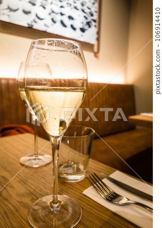 Wine glass with white wine on the table at an Italian restaurant in London Wine glass with white wine on the table at an Italian restaurant in London 106914410