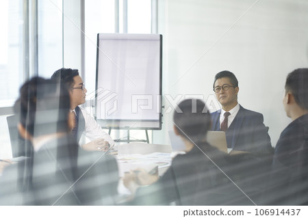 team of asian corporate executives discussing business in conference room 106914437