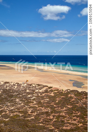 View over a wide beautiful bathing bay on the Canary Island Fuerteventura in the Atlantic Ocean , vertical photo View over a wide beautiful bathing bay on the Canary Island Fuerteventura in the Atlantic Ocean , vertical photo 106915094