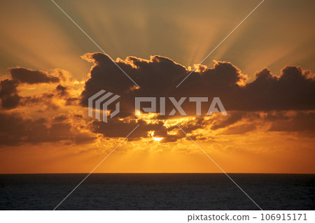 the beautiful sun behind clouds rises brilliantly over the Atlantic Ocean in the early morning the beautiful sun behind clouds rises brilliantly over the Atlantic Ocean in the early morning 106915171