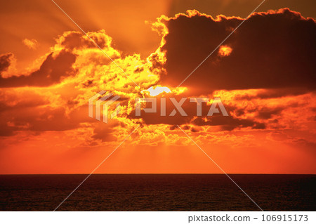 brilliant shining sun behind clouds rises radiantly over the Atlantic Ocean in the early morning brilliant shining sun behind clouds rises radiantly over the Atlantic Ocean in the early morning 106915173