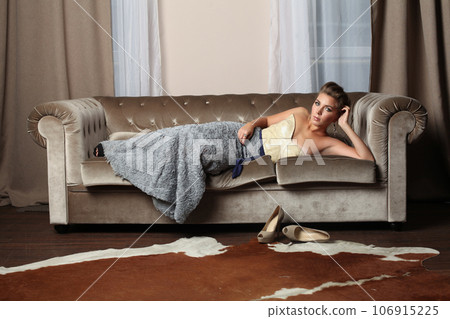 Beautiful woman fashion model in elegant evening dress posing in luxurious interior background Beautiful woman fashion model in elegant evening dress posing in luxurious interior background 106915225