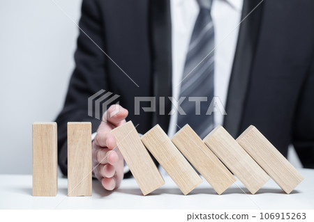 Wooden blocks under business protection, domino, insurance safety property concept, stop falling Wooden blocks under business protection, domino, insurance safety property concept, stop falling 106915263