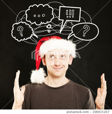 Man in Santa Hat showing his Hands with icons above his head. Sale Concept Man in Santa Hat showing his Hands with icons above his head. Sale Concept 106915267