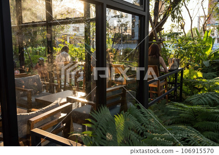 People sit and relax at coffee shop patio to drink with natural view 106915570