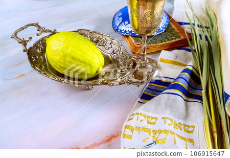 Sukkot, Jewish Orthodox festival, features use of traditional Holiday symbols such as four species Etrog, lulav, hadas, arava. 106915647