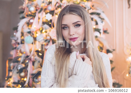 Charming blonde woman in warm sweater at home Charming blonde woman in warm sweater at home 106916012