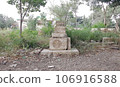 Blank gravestone with other graves and green neem trees in background 106916588