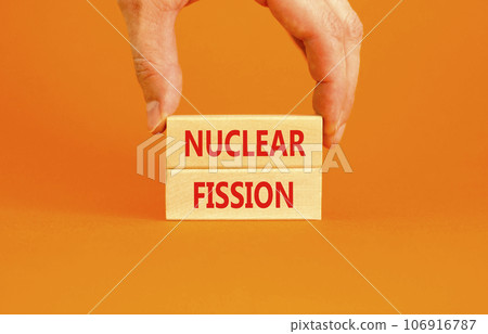 Nuclear fission symbol. Concept words Nuclear fission on beautiful wooden blocks. Beautiful orange table orange background. Businessman hand. Business science nuclear fission concept. Copy space. 106916787