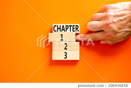 Time to chapter 1 symbol. Concept word Chapter 1 2 3 on wooden block. Businessman hand. Beautiful orange table orange background. Business planning and time to chapter 1 concept. Copy space. Time to chapter 1 symbol. Concept word Chapter 1 2 3 on wooden block. Businessman hand. Beautiful orange table orange background. Business planning and time to chapter 1 concept. Copy space. 106916836