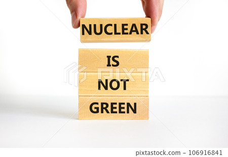 Nuclear is not green symbol. Concept words Nuclear is not green on wooden blocks. Businessman hand. Beautiful white table white background. Nuclear is not green business concept. Copy space. 106916841