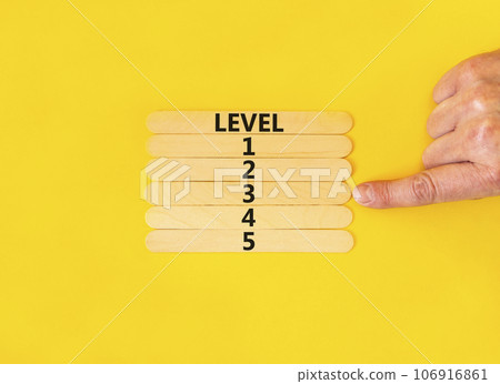 Time to level 3 symbol. Concept word Level 1 2 3 4 5 on wooden sticks. Businessman hand. Beautiful yellow table yellow background. Business planning and time to level 3 concept. Copy space. 106916861