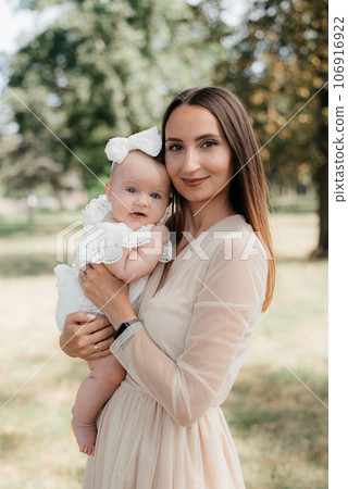 Young beautiful mother hugs with her child outdoor. 106916922