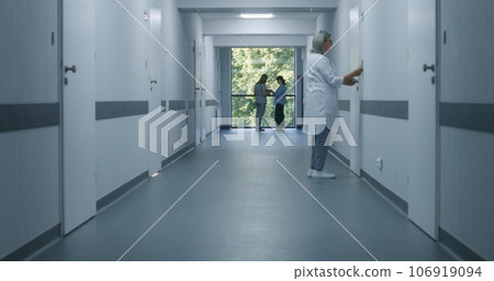 Medical staff and patients in modern hospital or medical center corridor Medical staff and patients in modern hospital or medical center corridor 106919094