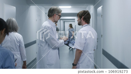 Doctor shows MRI, CT brain scan image to colleague using tablet Doctor shows MRI, CT brain scan image to colleague using tablet 106919273