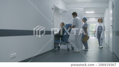 Doctor transports patient on wheelchair in cabinet for procedures 106919367