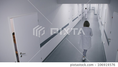 Medical staff, doctors and patients walking in clinic corridor Medical staff, doctors and patients walking in clinic corridor 106919376