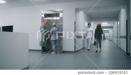 Nurse with old patient wait for elevator in medical center hallway Nurse with old patient wait for elevator in medical center hallway 106919381