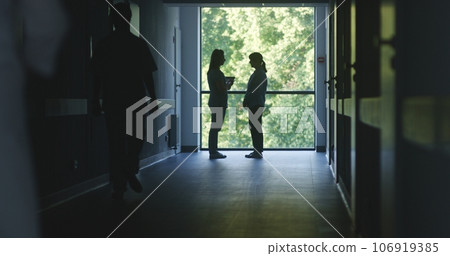 Medical staff and patients walk in dark clinic corridor 106919385