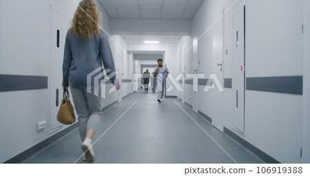 Woman goes corridor and asks doctor way to cabinet 106919388