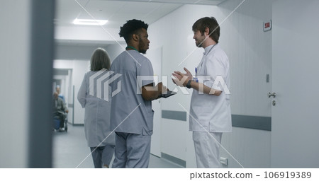 Young doctor discusses with other medic treatment 106919389