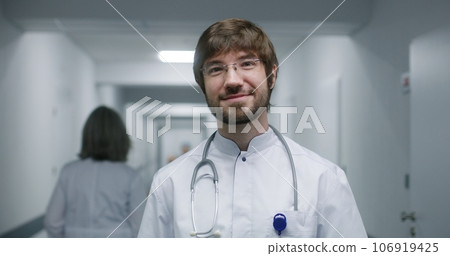 Young doctor in glasses looks at camera and smiles 106919425