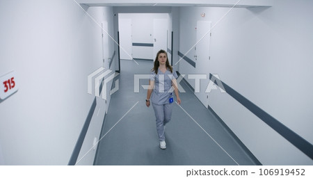 Doctors, nurses and diverse patients walking in hospital hallway 106919452