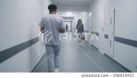 African American physician walks corridor 106919453