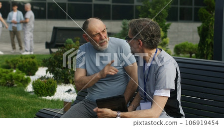 Specialist in medical uniform consults patient 106919454