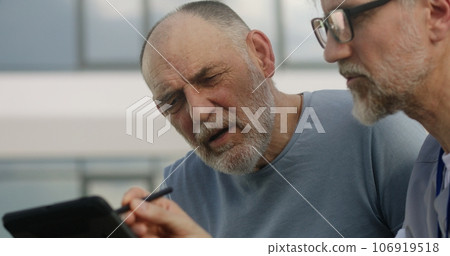 Elderly man complains of shoulders pains to doctor Elderly man complains of shoulders pains to doctor 106919518