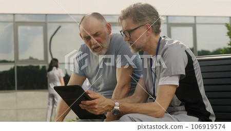 Mature doctor makes diagnosis to elderly patient 106919574