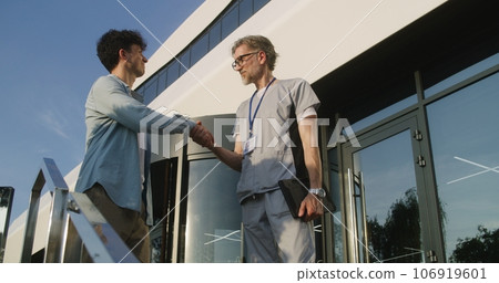 Doctor with tablet consults patient at entrance 106919601