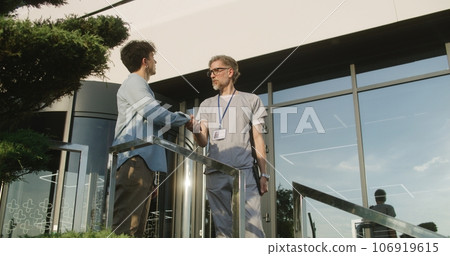 Doctor with tablet consults patient at entrance Doctor with tablet consults patient at entrance 106919615