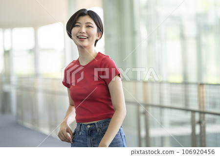 Portrait of a woman in her twenties smiling looking at the camera 106920456