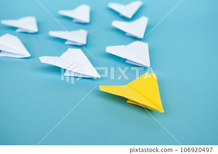 Top view of yellow paper airplane origami leading other white paper airplanes Top view of yellow paper airplane origami leading other white paper airplanes 106920497