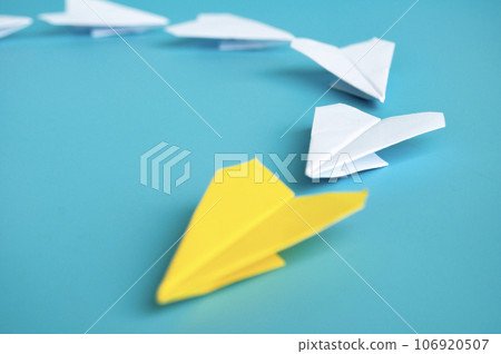 Low view of yellow paper plane origami leading white paper planes. With copy space for text. Low view of yellow paper plane origami leading white paper planes. With copy space for text. 106920507