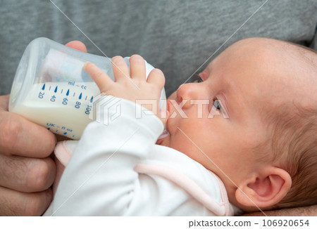 Man's journey into fatherhood, feeding his newborn baby formula from a bottle Man's journey into fatherhood, feeding his newborn baby formula from a bottle 106920654