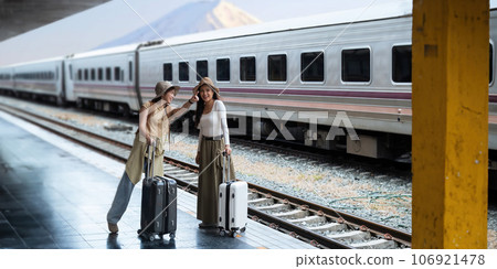 Young two woman with suitcase waiting for a train tourist adventure holiday traveling with mount fuji as the background concept transport lifestyle active journey and travel lifestyle Young two woman with suitcase waiting for a train tourist adventure holiday traveling with mount fuji as the background concept transport lifestyle active journey and travel lifestyle 106921478