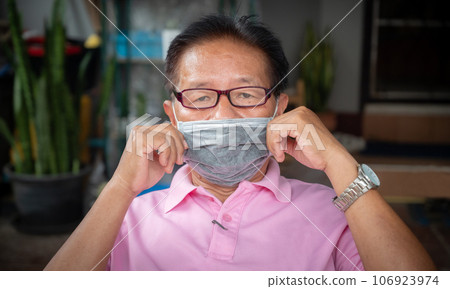 Asian senior man wearing surgical mask for protect virus disease or bad air pollution. Asian senior man wearing surgical mask for protect virus disease or bad air pollution. 106923974
