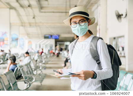 Asian woman wearing mask while travel during the COVID-19 Pandemic. During your trip should wear a mask to keep your nose and mouth covered when in public. Asian woman wearing mask while travel during the COVID-19 Pandemic. During your trip should wear a mask to keep your nose and mouth covered when in public. 106924007