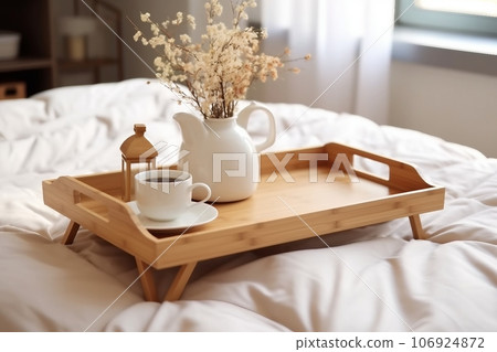Wooden tray with coffee and interior decor on the bed with white linen Wooden tray with coffee and interior decor on the bed with white linen 106924872