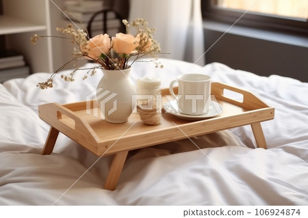 Wooden tray with coffee and interior decor on the bed with white linen Wooden tray with coffee and interior decor on the bed with white linen 106924874