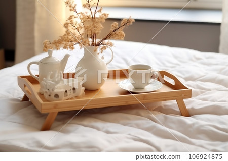Wooden tray with coffee and interior decor on the bed with white linen Wooden tray with coffee and interior decor on the bed with white linen 106924875