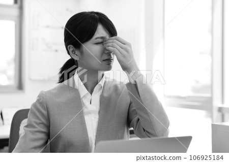 Monochrome image of a tired female office worker 106925184