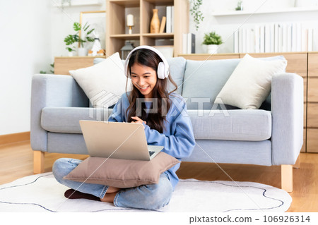Young Asian Woman Having a Video Call on Laptop in a Cozy Home Office 106926314